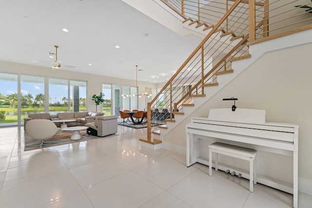 interior space featuring ceiling fan with notable chandelier and light tile patterned floors