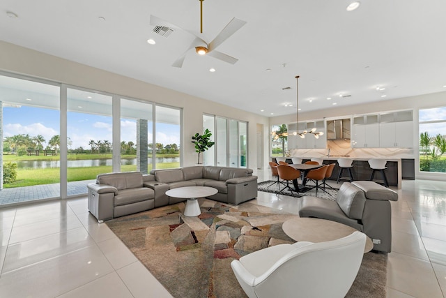 tiled living room featuring a water view and ceiling fan