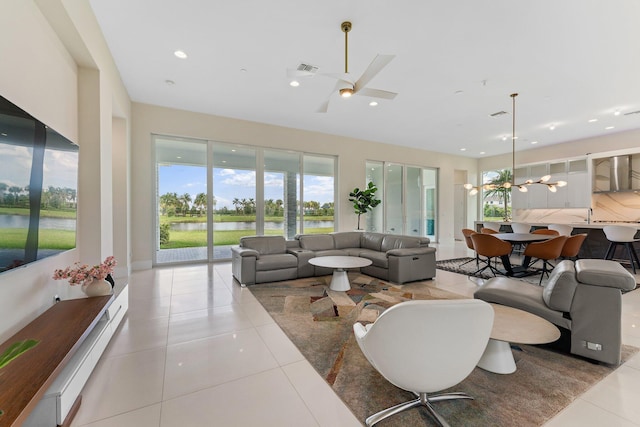 tiled living room featuring a water view and ceiling fan