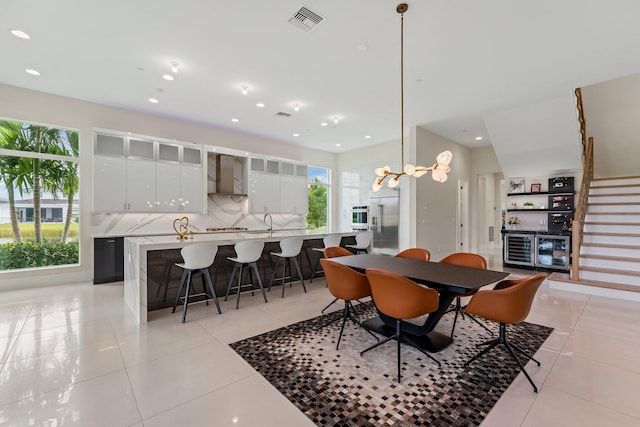 tiled dining room with an inviting chandelier