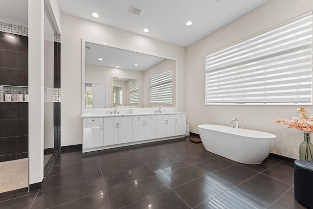 bathroom with tile patterned flooring, vanity, a healthy amount of sunlight, and separate shower and tub