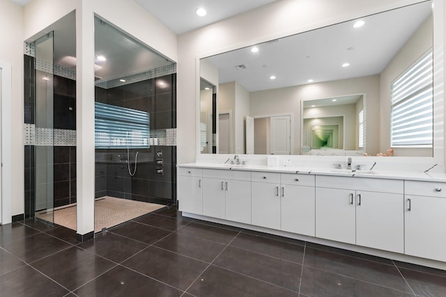 bathroom featuring vanity, tiled shower, and tile patterned flooring