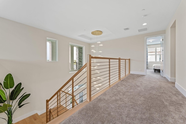 hallway with plenty of natural light and light carpet