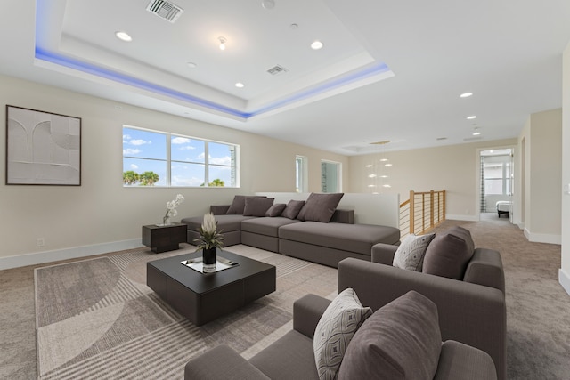 carpeted living room featuring a raised ceiling