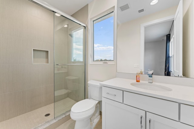 bathroom featuring vanity, toilet, and an enclosed shower