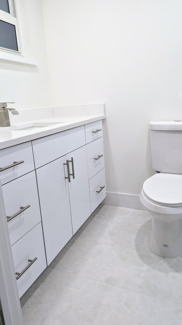 bathroom featuring vanity, concrete floors, and toilet