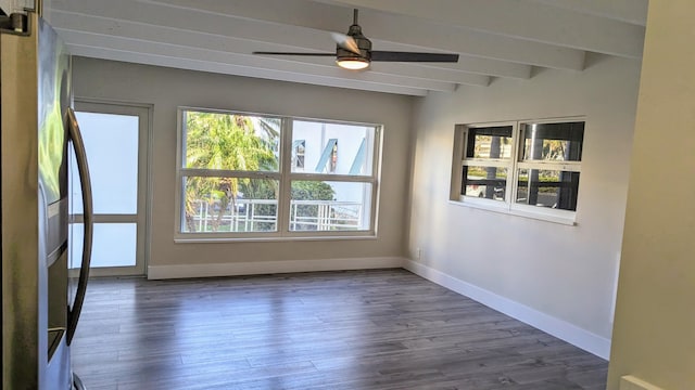 unfurnished room with a wealth of natural light, ceiling fan, beamed ceiling, and dark hardwood / wood-style floors