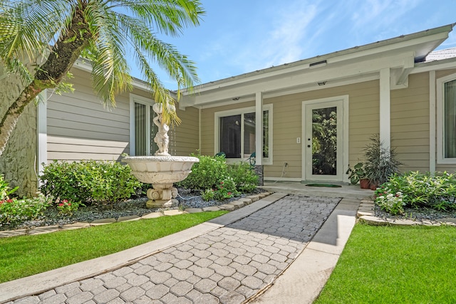 view of exterior entry featuring a yard