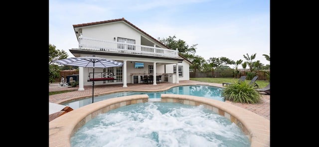 6785 Escondida Dr, Lake Clarke Shores, FL 33406 - rear view of house with a balcony, fence, an outdoor pool, a patio area, and an in ground hot tub