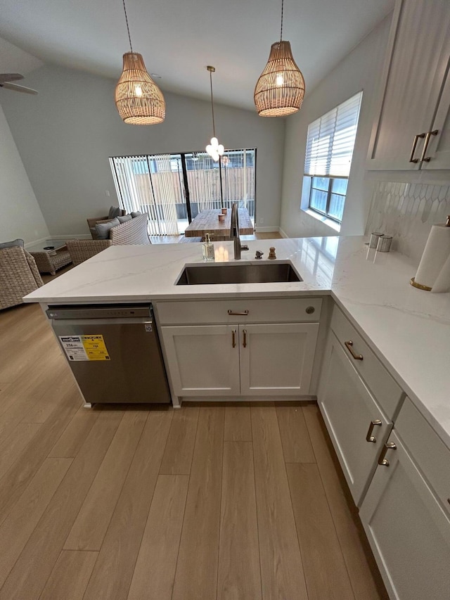 kitchen featuring white cabinetry, dishwasher, hanging light fixtures, and sink