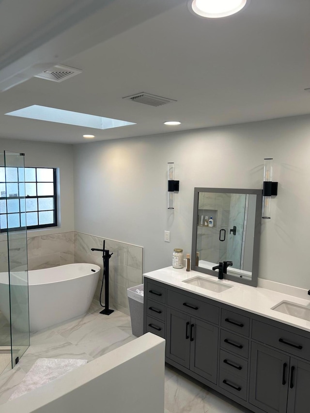 bathroom with independent shower and bath, a skylight, and vanity