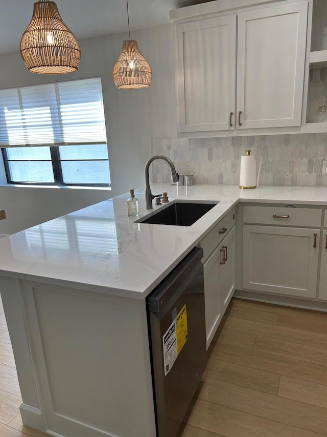 kitchen featuring backsplash, dishwasher, hanging light fixtures, white cabinets, and sink