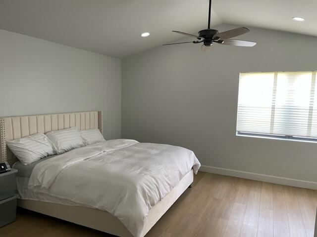 bedroom featuring vaulted ceiling, ceiling fan, and wood-type flooring