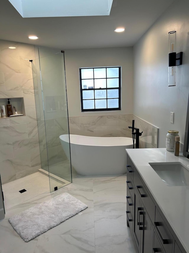 bathroom featuring vanity, tile walls, and shower with separate bathtub