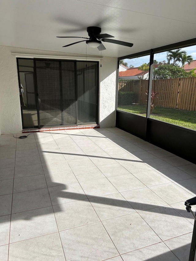 unfurnished sunroom with ceiling fan