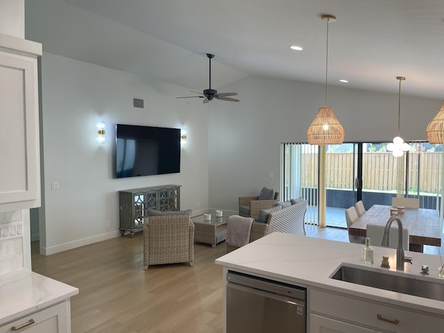 kitchen featuring white cabinetry, lofted ceiling, dishwasher, hanging light fixtures, and sink