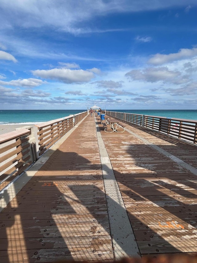 view of dock featuring a view of the beach and a water view