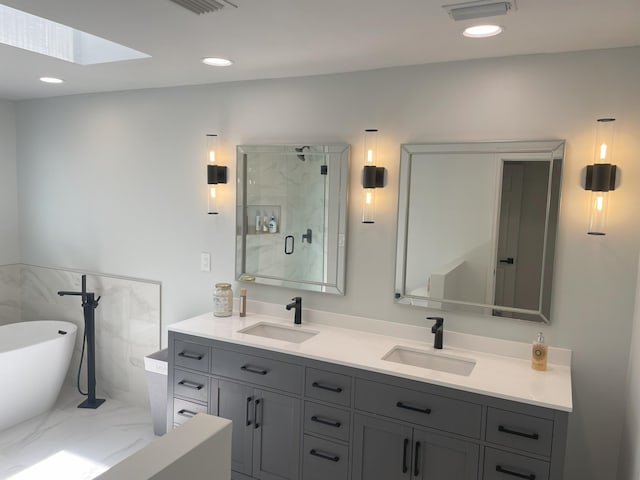 bathroom featuring vanity, a skylight, and independent shower and bath