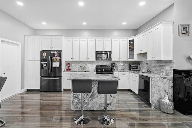 kitchen featuring black refrigerator with ice dispenser, electric range oven, dishwashing machine, and light stone countertops