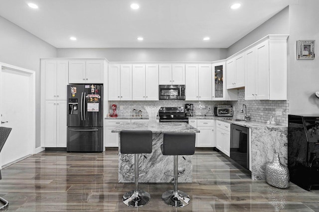 9859 Boca Gardens Cir Unit B, Boca Raton, FL 33496 - kitchen with tasteful backsplash, light stone counters, black appliances, a sink, and white cabinetry