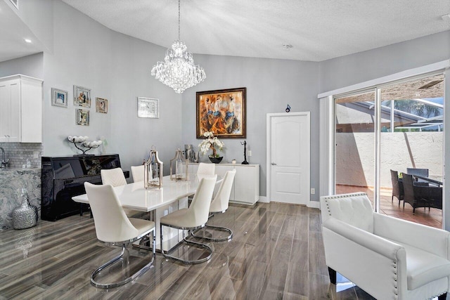 dining area featuring hardwood / wood-style floors, high vaulted ceiling, a notable chandelier, and a textured ceiling