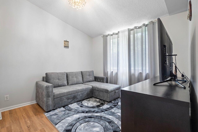 9859 Boca Gardens Cir Unit B, Boca Raton, FL 33496 - living room featuring lofted ceiling, a textured ceiling, wood finished floors, and baseboards