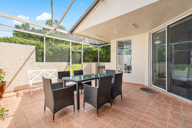 view of patio featuring glass enclosure