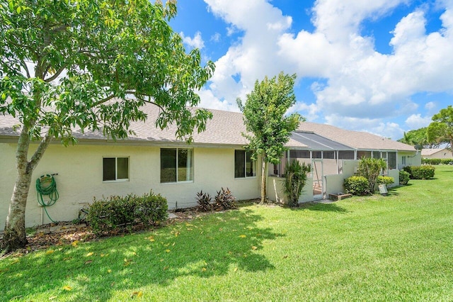 9859 Boca Gardens Cir Unit B, Boca Raton, FL 33496 - back of property featuring roof with shingles, glass enclosure, stucco siding, and a lawn