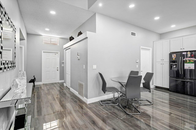 dining space with a textured ceiling and dark hardwood / wood-style flooring