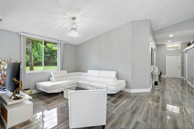 living room with vaulted ceiling, a textured ceiling, hardwood / wood-style floors, and a chandelier