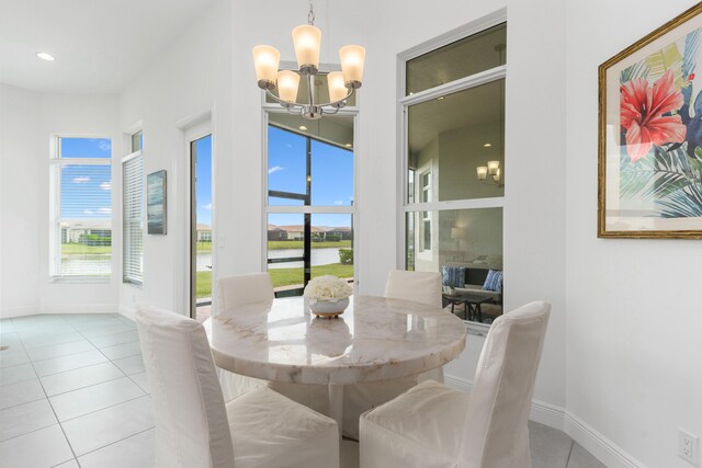 dining space with a notable chandelier, plenty of natural light, and light tile patterned floors