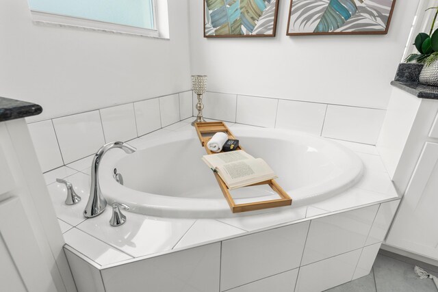 bathroom featuring tile patterned flooring and tiled tub