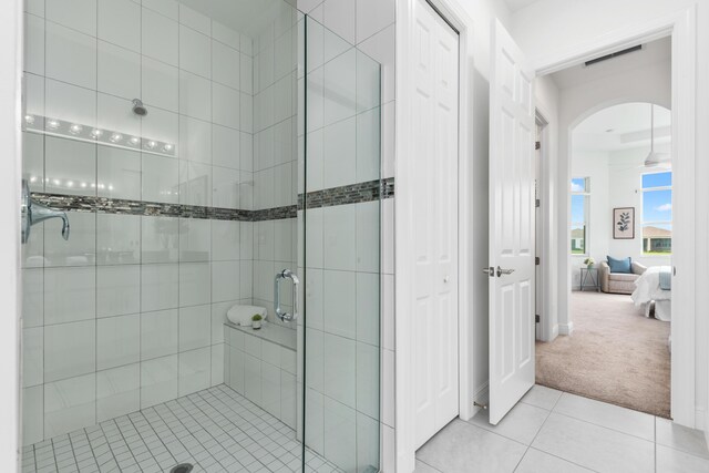 bathroom with a shower with shower door and tile patterned flooring