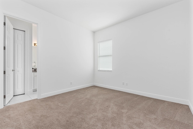 unfurnished room featuring light colored carpet