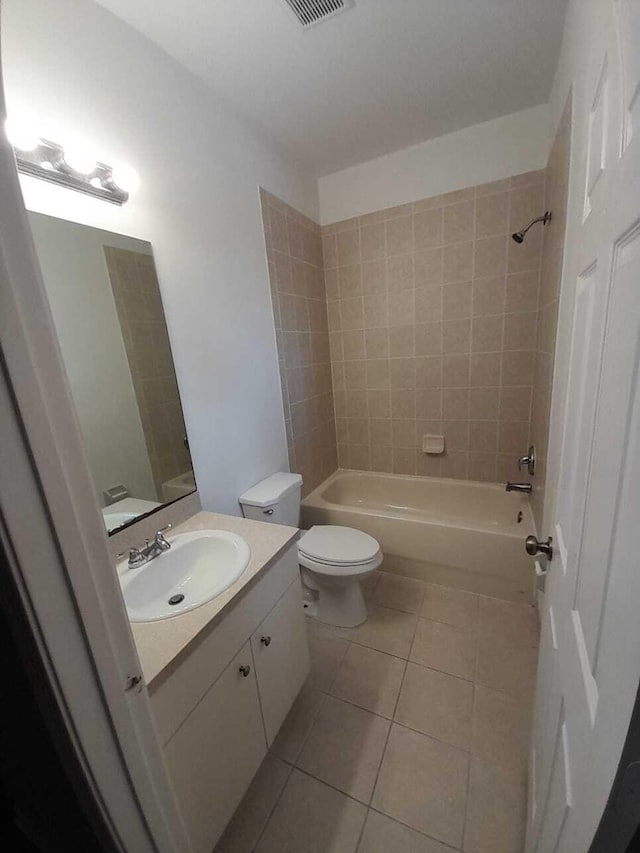 full bathroom with tiled shower / bath, toilet, tile patterned floors, and vanity