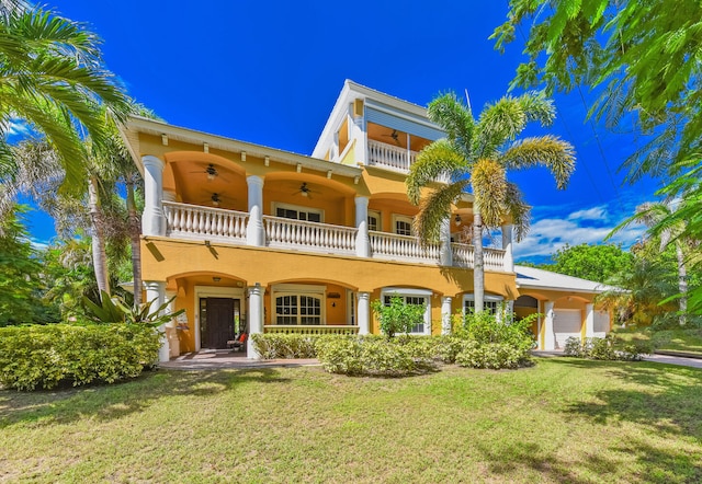 view of front of home with a front lawn, a balcony, a garage, and ceiling fan