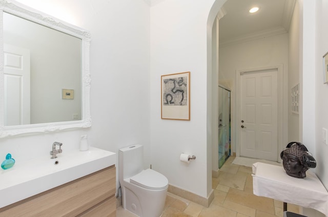 full bathroom with baseboards, toilet, crown molding, vanity, and a shower stall