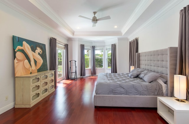 bedroom featuring a tray ceiling, ceiling fan, crown molding, and hardwood / wood-style flooring