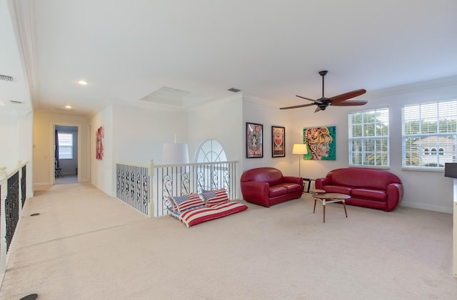 carpeted living room with ceiling fan and crown molding