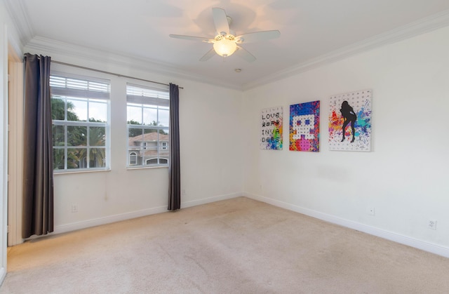 carpeted empty room featuring baseboards, a ceiling fan, and crown molding