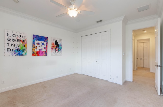 unfurnished bedroom with ceiling fan, ornamental molding, a closet, and light carpet