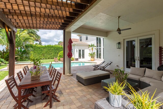 view of patio featuring ceiling fan, an outdoor hangout area, french doors, and a fenced in pool