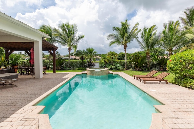 view of pool with outdoor dining space, a pool with connected hot tub, a patio area, and a gazebo