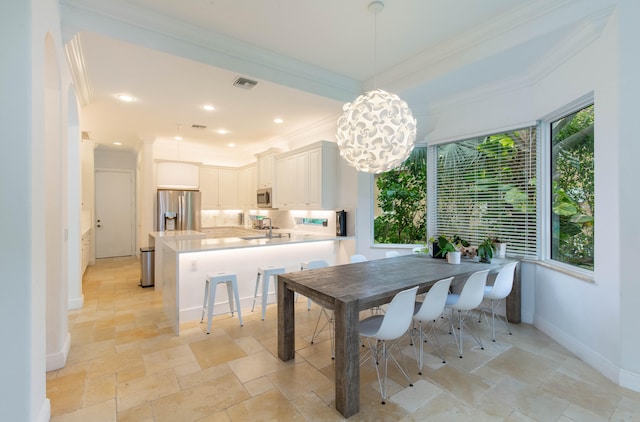 tiled dining room with sink and ornamental molding