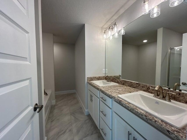 bathroom with vanity, a textured ceiling, and a bathing tub