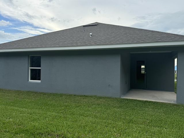 5483 Lugo St, Fort Pierce, FL 34951 - back of house featuring a lawn, roof with shingles, and stucco siding