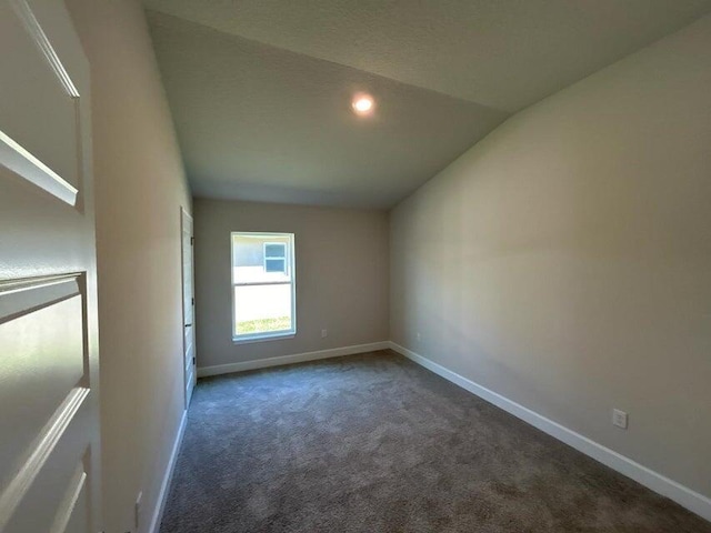 carpeted spare room with lofted ceiling