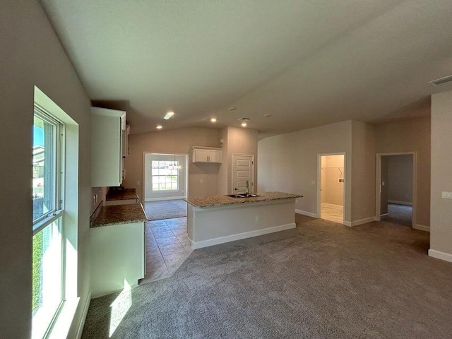 unfurnished living room featuring light colored carpet, lofted ceiling, and sink