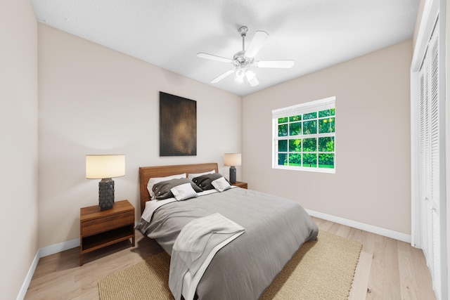 bedroom featuring ceiling fan, light wood-type flooring, and a closet