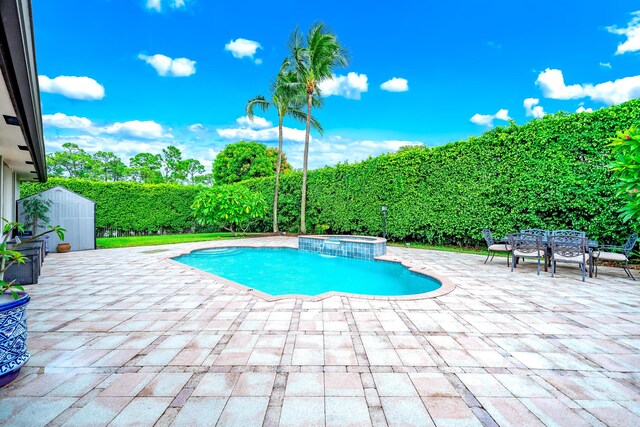 view of pool featuring an in ground hot tub, a patio, and a storage unit